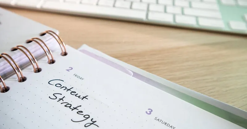 Content strategy written in planner with keyboard on wooden desk