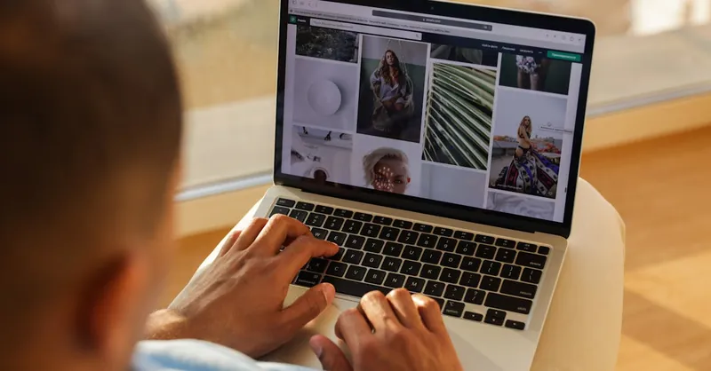 Close-up of a person using a laptop indoors while browsing a photography portfolio.
