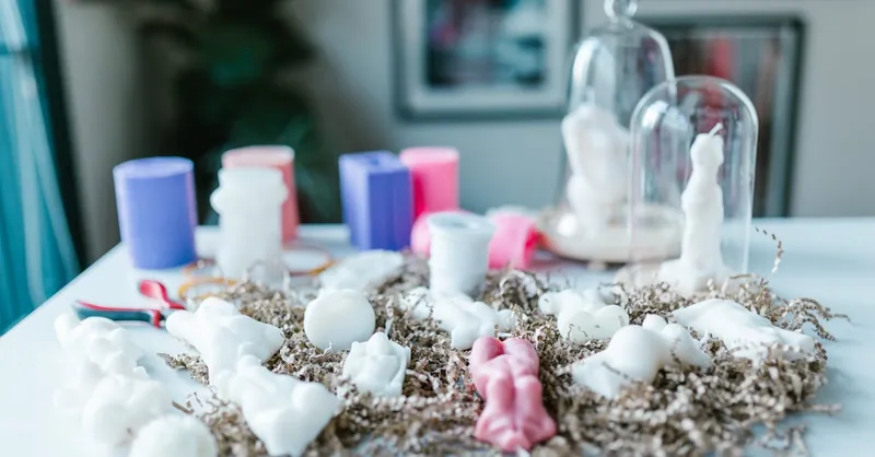 Artistic arrangement of handmade candles on a table with a focus on creativity and craft.