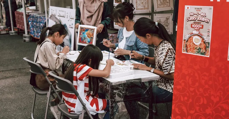 Family creating artwork together at an outdoor market. Engaging community event with children painting.