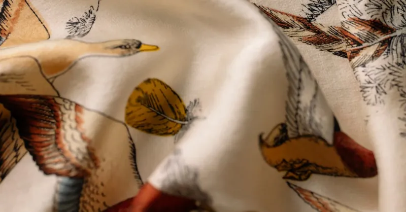 Detailed bird illustrations on draped fabric, showcasing vintage art style.
