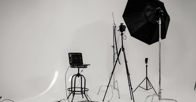A black and white photo of a well-equipped photography studio with lighting equipment and tripods.
