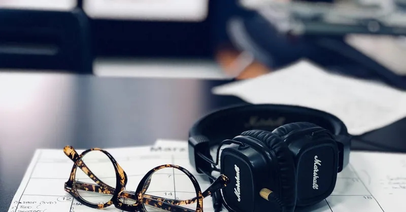 Glasses and headphones on a desk calendar, highlighting a modern workspace setup.